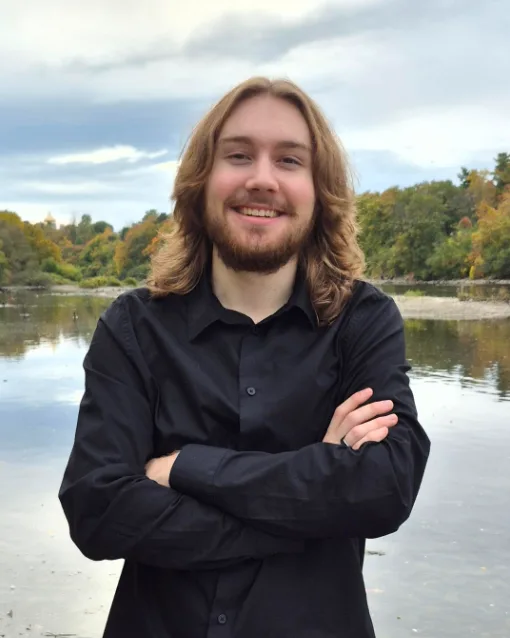 Nicholas MacInnes, founder of Fury Web Design, standing with arms crossed in front of the Ottawa River